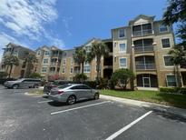 Three story building exterior with tan colored siding, balconies and palm trees at 7671 Comrow St # 302, Kissimmee, FL 34747