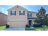 Two-story house with two-car garage and landscaping at 108 Country Walk Cir, Davenport, FL 33837