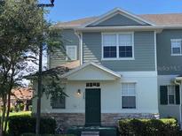 Two-story house with gray siding and green door at 2884 Grasmere View Pkwy, Kissimmee, FL 34746