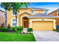 Two-story house with attached garage and manicured lawn at 1038 Orange Cosmos Blvd, Davenport, FL 33837