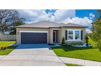 One-story home with dark brown garage door and landscaping at 2765 Quilla Ct, Kissimmee, FL 34758