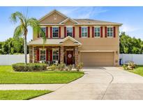 Two-story house with stone accents and red shutters at 108 Colonial Pine Ln, Minneola, FL 34715