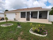 Charming single-story home with a screened porch and well-manicured lawn at 2518 Bowmer Dr, Kissimmee, FL 34744