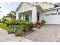 Inviting front yard with colorful landscaping and brick pavers at 5012 E Fountainwood Dr, Saint Cloud, FL 34772