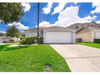 Single story home with attached garage and well-manicured lawn at 104 Langham Dr, Davenport, FL 33897