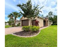 Tan house with two-car garage and landscaped yard at 790 Shady Canyon Way, Poinciana, FL 34759