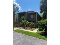 Dark brown two-story condo with wood siding and a small fenced yard at 5341 Indian Creek Dr # B, Orlando, FL 32811