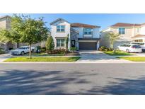 Two-story house with stone accents, a large garage, and landscaping at 9032 Flamingo Key Way, Kissimmee, FL 34747
