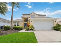 Two-story house with attached garage, landscaping and driveway at 241 Grosvenor Loop, Davenport, FL 33897