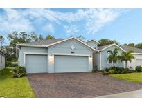 Light blue house with two-car garage and landscaped yard at 6282 Lakepine St, Saint Cloud, FL 34771