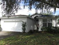 One-story house with a white exterior, attached garage and manicured lawn at 216 Balmoral Ct, Davenport, FL 33896