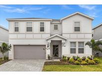 Two-story house with a gray garage door and landscaping at 3209 Lilac Way, Davenport, FL 33897