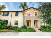 Two-story townhouse with a brick walkway and lush landscaping at 9047 Rhodes St, Kissimmee, FL 34747