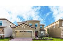 Two-story house with a three car garage and well-manicured lawn at 1495 Rolling Fairways Dr, Davenport, FL 33896