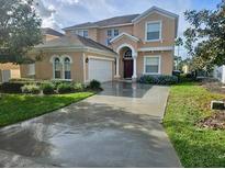 Two-story house with a large driveway and landscaped yard at 476 Calabay Parc Blvd, Davenport, FL 33897