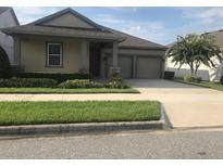 Beautiful two-car garage home with well-manicured lawn at 15231 Honeybell Dr, Winter Garden, FL 34787