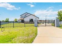 Two-story home with gated entrance and landscaping at 1980 Poblado Ct, Kissimmee, FL 34744