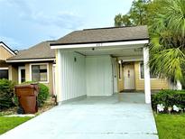 Front view of a house with carport, landscaping, and a paved driveway at 457 Prestwick Pl # 457, Kissimmee, FL 34759