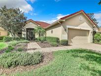 Single-story home with red tile roof, neutral exterior, and landscaped front yard at 722 Coronado Dr, Kissimmee, FL 34759