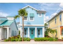 Charming light blue two-story home with teal door and palm tree at 3037 Sea Plane Ln, Kissimmee, FL 34747