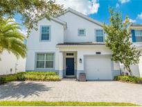 Two-story house with white exterior, paver driveway and landscaping at 4722 Sleepy Hollow Dr, Kissimmee, FL 34746