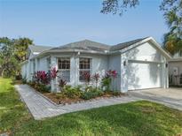 White house with gray roof, landscaping, and paved walkway at 205 Bell Tower W Xing, Kissimmee, FL 34759