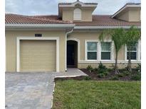 Tan house with a modern design and an attached garage at 1077 Quaker Ridge Ln, Davenport, FL 33896