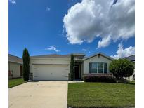 Single-story house with a two-car garage and landscaped lawn at 1837 Hickory Bluff Rd, Kissimmee, FL 34744