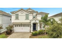 Two-story house with white exterior and a two-car garage at 8839 Interlocking Ct, Davenport, FL 33896