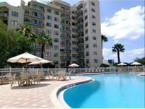 Resort-style pool and building exterior with patio furniture at 6165 Carrier Dr # 2314, Orlando, FL 32819