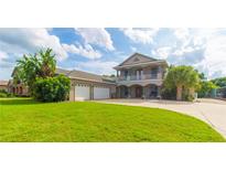 Two-story home with three-car garage and lush landscaping at 1380 E Lake Shore Blvd, Kissimmee, FL 34744