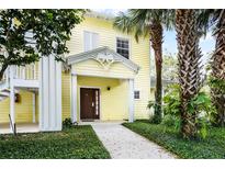 Charming yellow two-story building with lush landscaping and welcoming entrance at 306 Lucaya Loop # B5/U306, Davenport, FL 33897