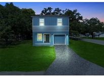 Two-story blue house with a garage at night at 1024 Carlisle St, Haines City, FL 33844