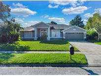 Single story home with a gray exterior, two-car garage and green lawn at 5232 Deer Creek Dr, Orlando, FL 32821