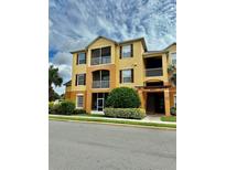 Three-story apartment building with yellow exterior and landscaping at 6265 Contessa Dr # 101, Orlando, FL 32829