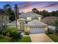 Two-story home with three-car garage and lush landscaping at 1049 Lake Berkley Dr, Kissimmee, FL 34746