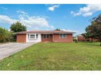 Brick home with a large yard, and driveway at 7819 Puritan Rd, Orlando, FL 32807