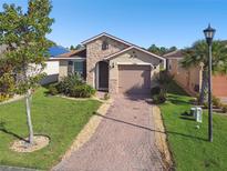 One-story house with a brick driveway and landscaping at 1294 Harbor Ridge Dr, Kissimmee, FL 34759