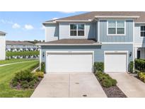 Two-car garage with walkway leading to front door of townhome at 4523 Cypress Cay Way, Kissimmee, FL 34746