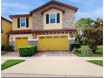 Two story home with stone and yellow siding, and a two car garage at 14315 Swanley St, Orlando, FL 32832