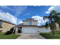 Two-story house with attached garage and palm tree at 3011 Bransbury Ct, Kissimmee, FL 34747