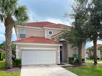 Two story house with tan exterior, tile roof and a two car garage at 256 Sevilla Ave, Davenport, FL 33897