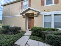 House exterior with a brown door and manicured shrubs at 10791 Gran Paradiso Dr # S, Orlando, FL 32832