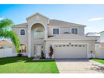 Two story home with landscaped lawn and attached garage at 1746 Pompano Dr, Poinciana, FL 34759