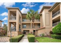 Tan building with balconies and lush landscaping at 901 Charo Pkwy # 721, Davenport, FL 33897