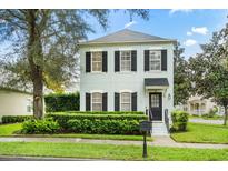 Two-story light blue house with black shutters at 900 Pawstand Rd, Celebration, FL 34747