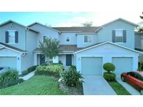 Two-story townhome with attached garage and landscaping at 1034 Chalcedony St, Kissimmee, FL 34744