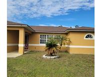 Tan house with brown roof, landscaping, and a covered entryway at 1325 Dunbarton Ct, Kissimmee, FL 34758