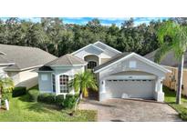 Two-story house with light beige exterior and a two-car garage at 520 Vista Oaks Way, Davenport, FL 33837