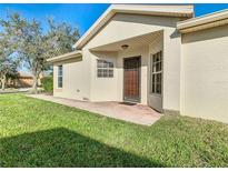 Tan house with a covered entryway and brick walkway at 657 Vineyard Way, Kissimmee, FL 34759